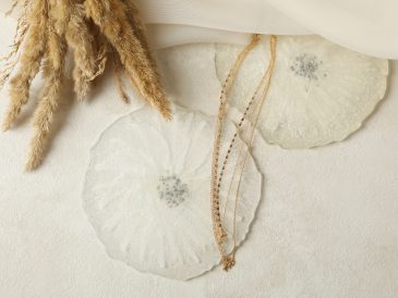 Epoxy resin, fabric, golden chain and field flowers on white background