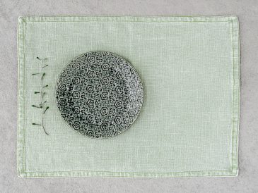 Green ceramic plate on linen placemat
