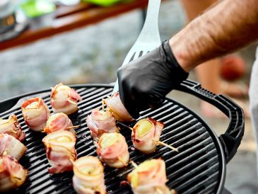 Grilled potato with bacon on gas grill .